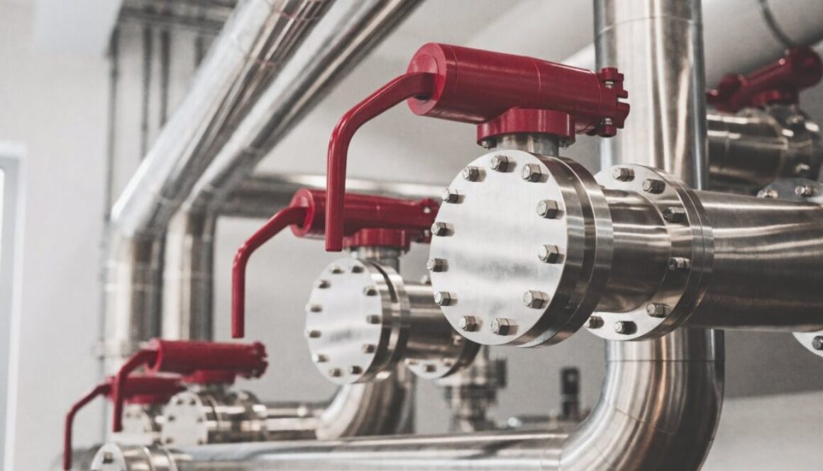 Industrielle Edelstahl-Rohrleitung mit geflanschten Absperrklappen und roten Hebeln